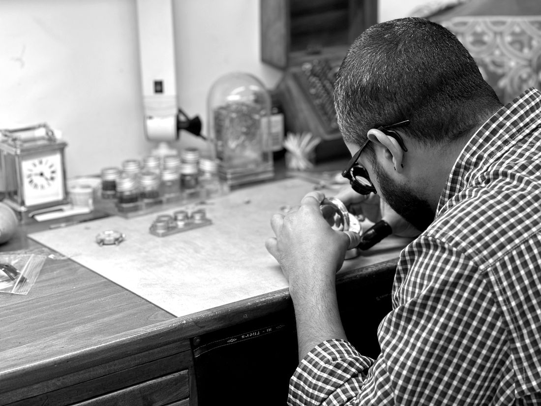 Ash, watchmaker & clockmaker, repairing a pocket watch at the bench at Alpha Time in Howick